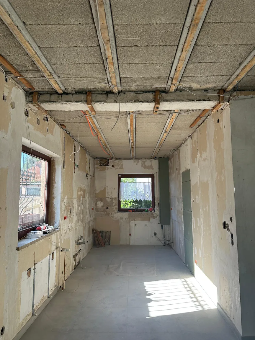 Küchenbereich mit freigelegter Decke und unbearbeiteten Wandflächen