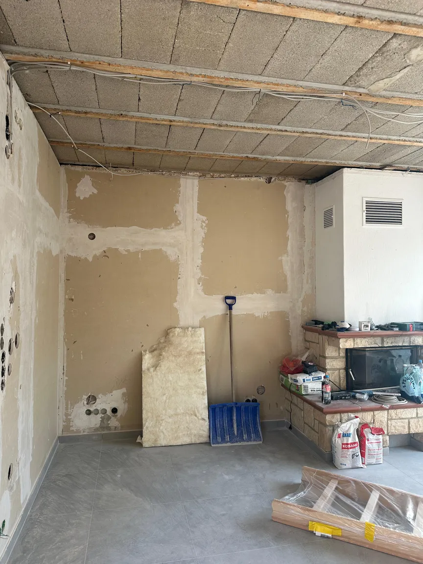 Wohnbereich mit Kamin, Baumaterialien und offener Decke