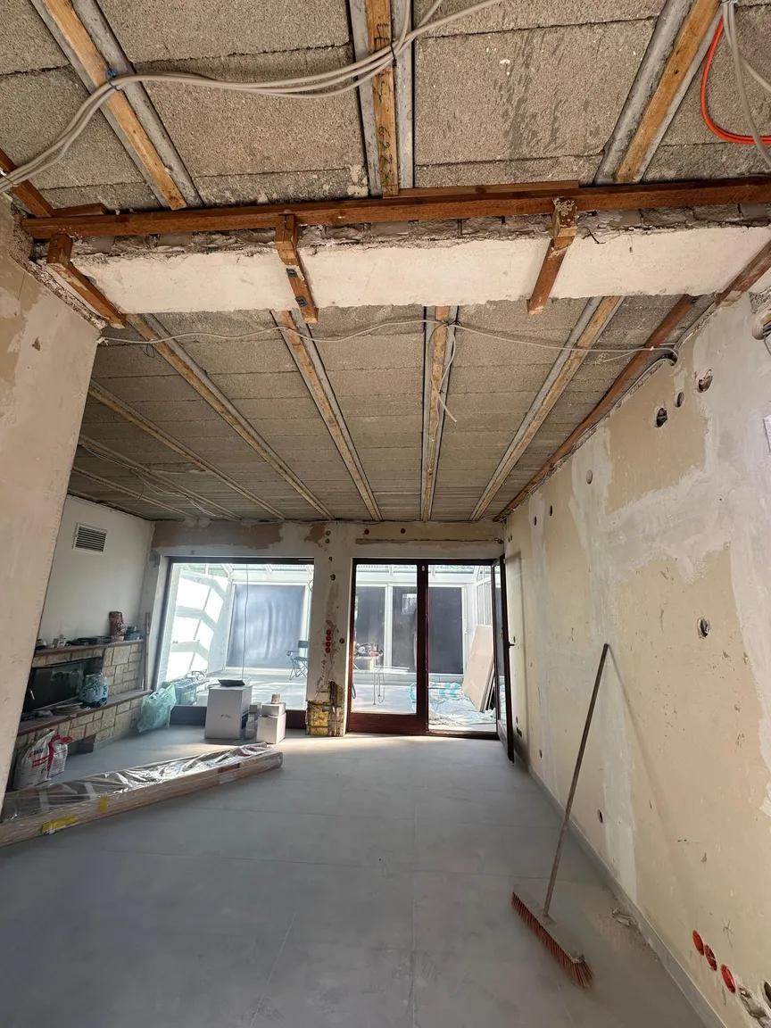 Wohnraum mit freigelegter Deckenkonstruktion und Blick zum Wintergarten