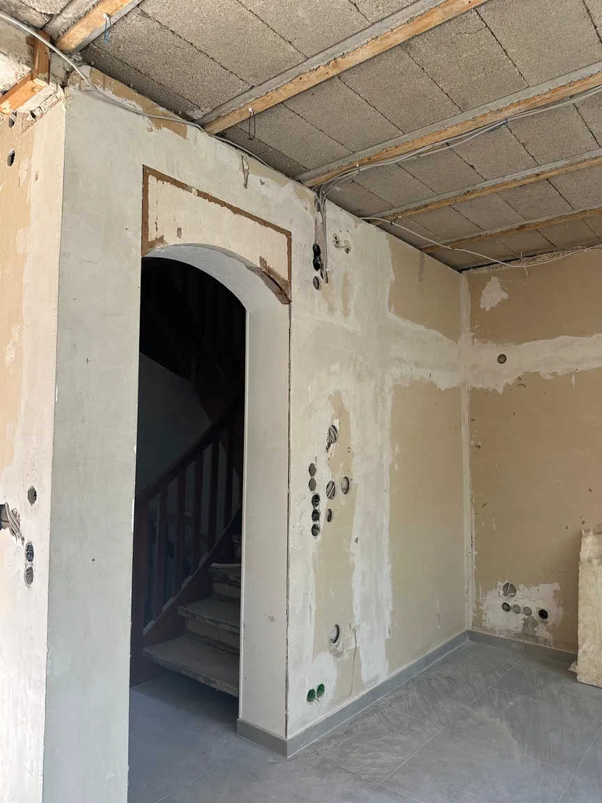 Rundbogendurchgang mit unbearbeiteten Wandflächen und offener Decke