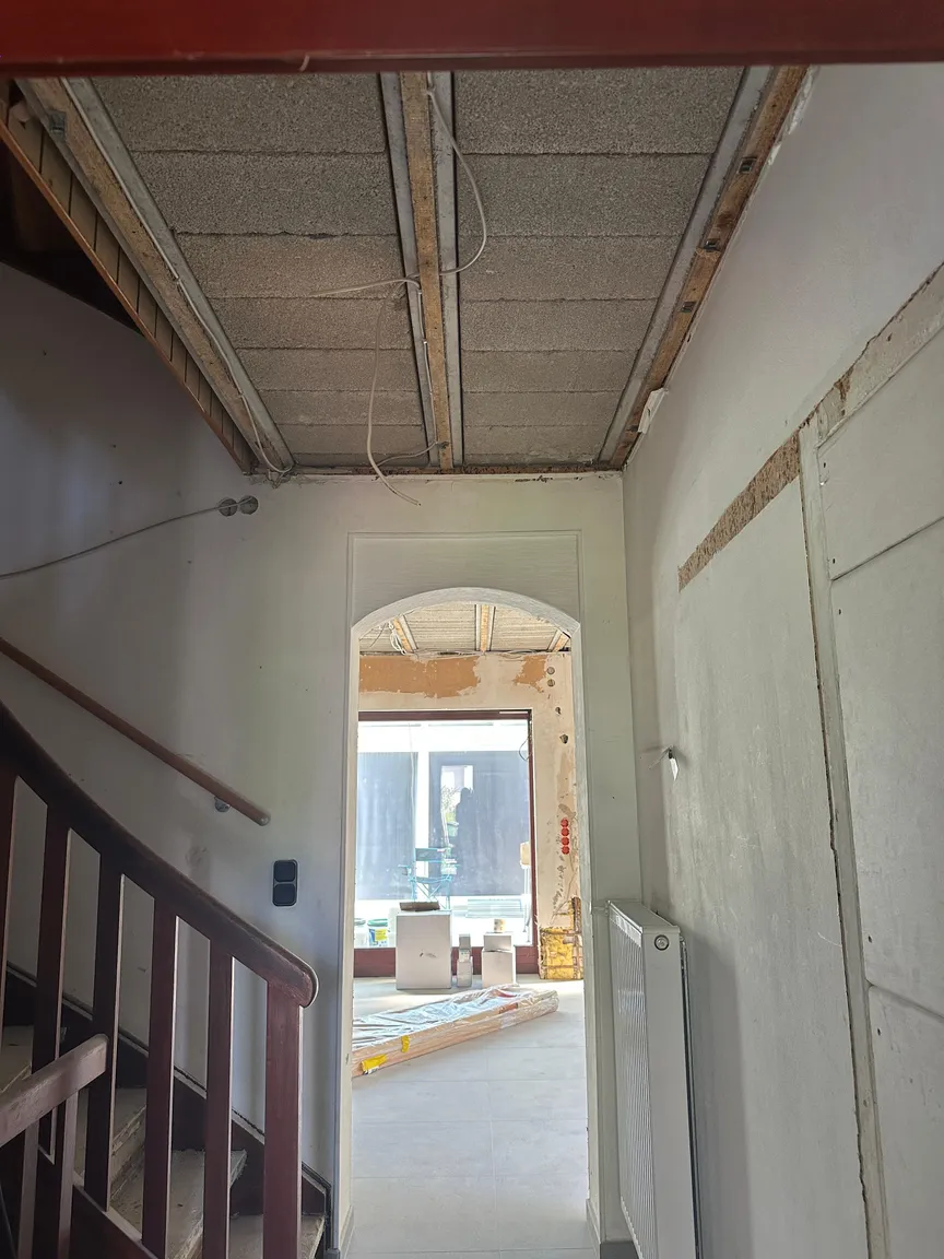 Flur mit Treppe, offener Decke und Durchgang zum Wohnraum